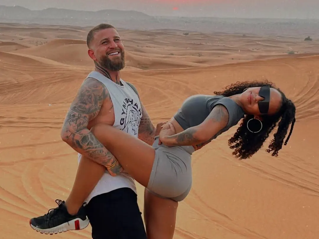 Couple posing on the dunes at sunset on an evening desert safari