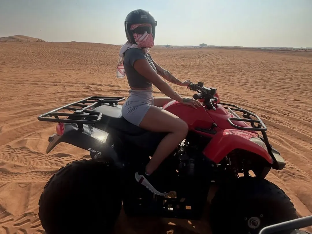 Rider on a red quad bike on the open red dunes outside Dubai