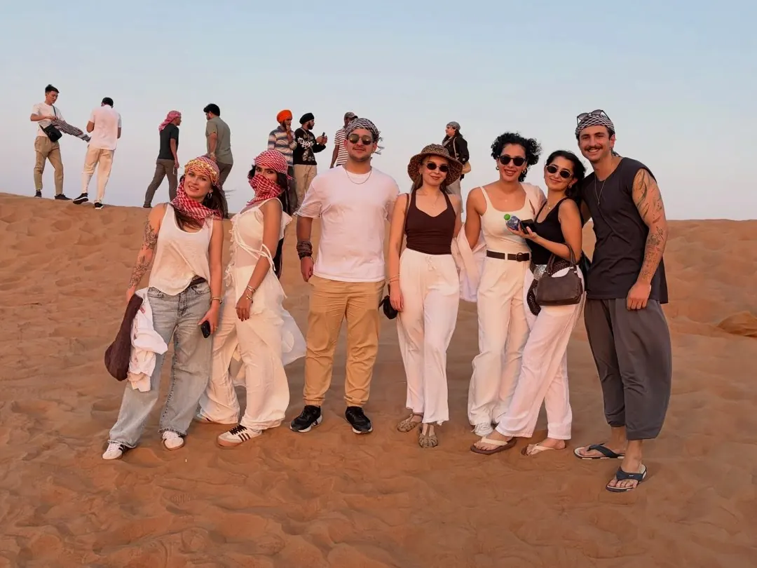 A group of guests standing on a sand dune during a Dubai desert safari