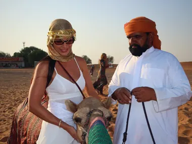 Guest meeting a camel and handler at the desert camp